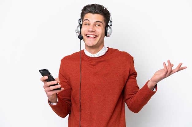 Telemarketer caucasian man working with a headset isolated on white background keeping a conversation with the mobile phone with someone