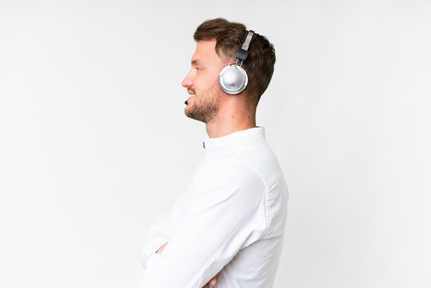 telemarketer caucasian man working with a headset over isolated white background in lateral position