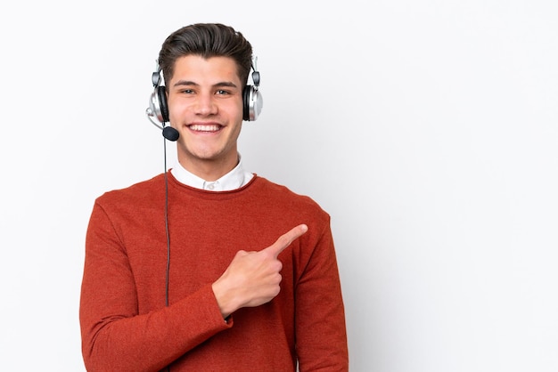 Telemarketer caucasian man working with a headset isolated on white background pointing to the side to present a product