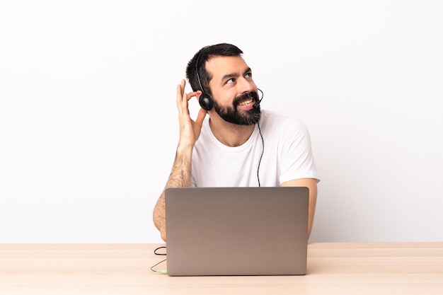 Telemarketer caucasian man working with a headset and with laptop thinking an idea.