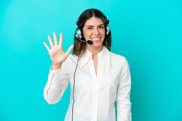 Telemarketer Italian woman working with a headset isolated on blue background counting five with fingers