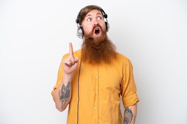 Telemarketer man isolated on white background thinking an idea pointing the finger up