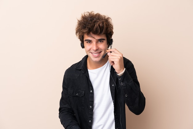 Telemarketer man working with a headset over isolated wall