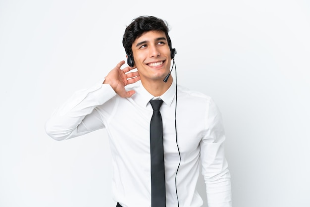 Telemarketer man working with a headset isolated on white background thinking an idea