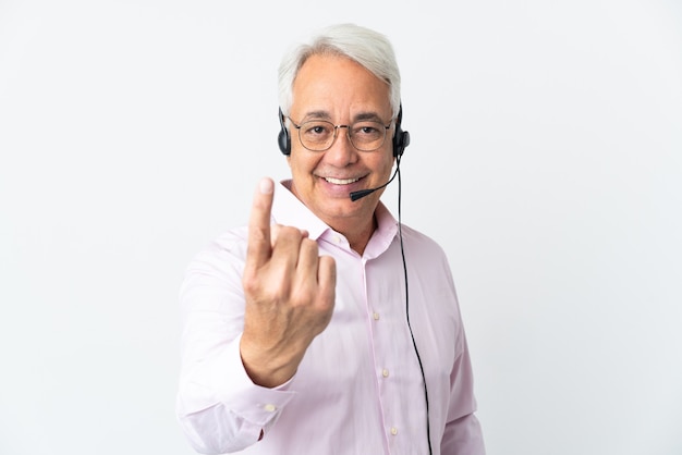 Telemarketer Middle age man working with a headset isolated on white background doing coming gesture