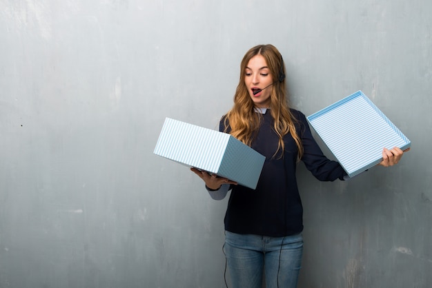 Telemarketer woman holding gift box in hands