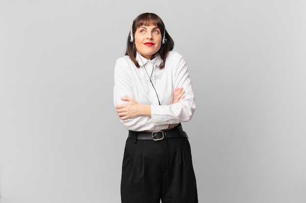 Telemarketer woman shrugging, feeling confused and uncertain, doubting with arms crossed and puzzled look