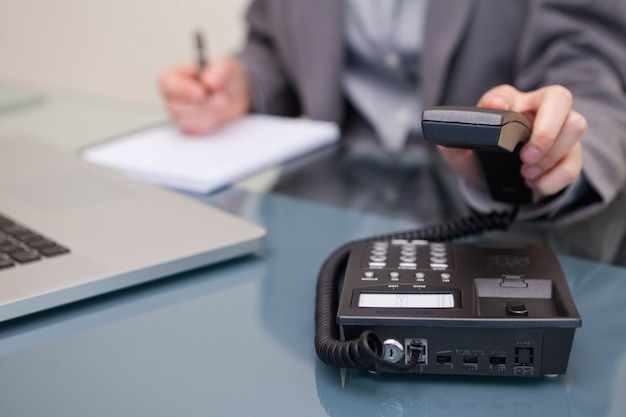 Telephone being hung up by businesswoman