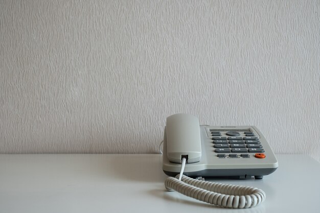 Telephone on the desk at gray wall background