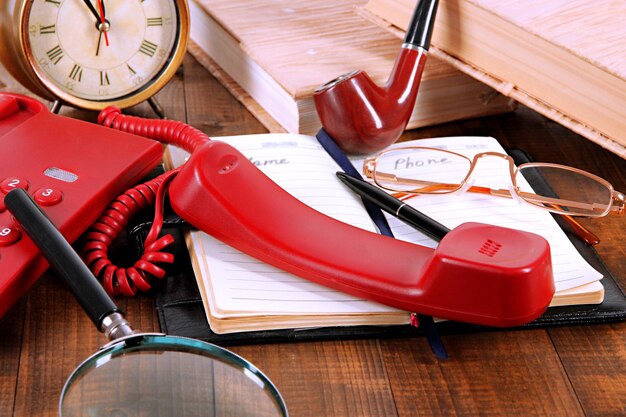 Photo telephone and notepad and other items on wooden background