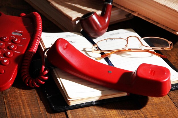 telephone and notepad and other items on wooden background