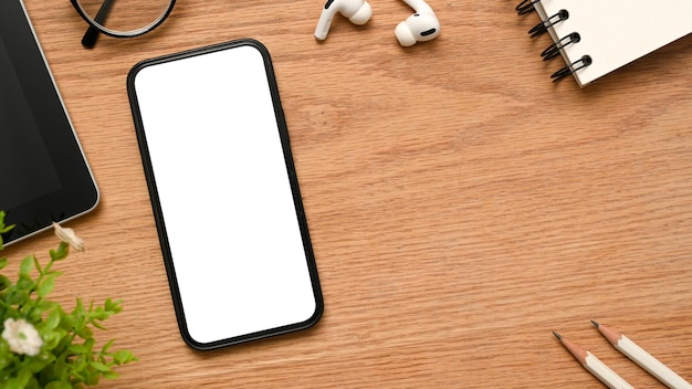 A telephone white empty screen mockup on minimal wooden desk background with copy space