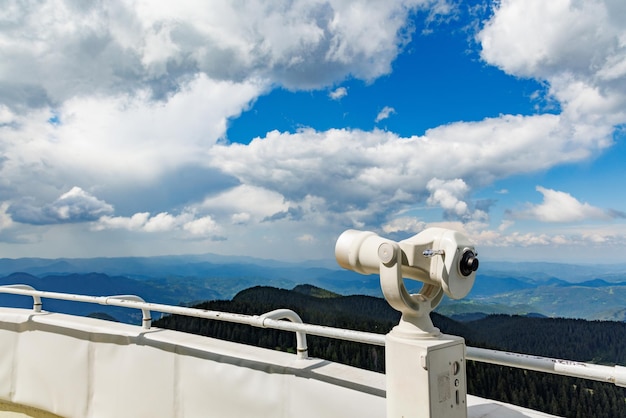 Telescope on a observation tower above a valley of the Rhodope mountains against a cloudy sky