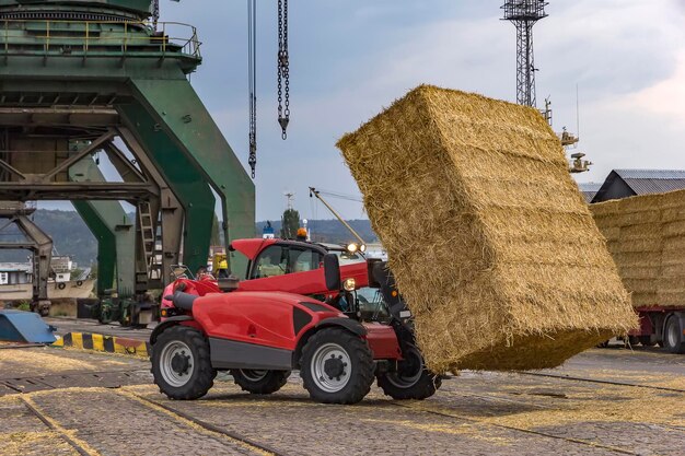 Photo telescopic handler unloading bales from truck day view