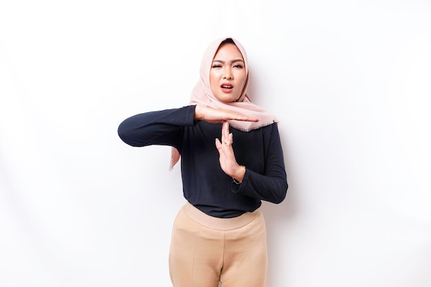 Teleurgestelde Aziatische moslimvrouw die een hijab draagt, geeft duim omlaag handgebaar van afkeuring geïsoleerd door witte achtergrond