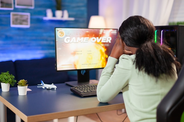 Teleurgestelde trieste afrikaanse vrouw na het verliezen van online gamecompetitie Boze professionele gamer gamen tijdens een space shooter online videogame.