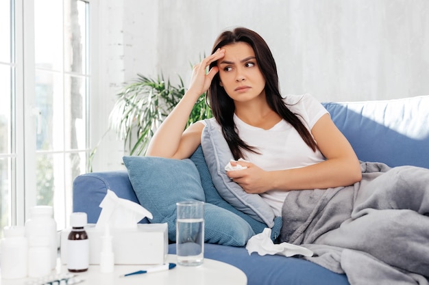 Foto teleurgestelde vrouw die wegkijkt terwijl ze thuis rust tijdens ziekte