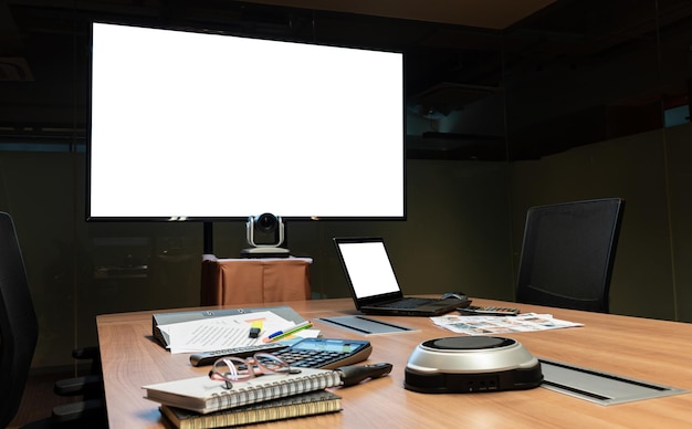 회의실의 테이블에 있는 텔레비전 및 노트북 흰색 화면 디스플레이 및 회의 장비