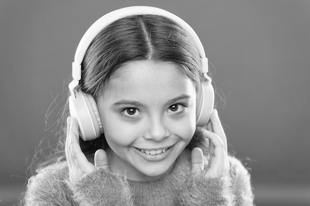 Tell me what you listen to and I will tell you who you are Girl cute little child wear headphones listen music Kid listen music orange background Recommended music based on initial interest