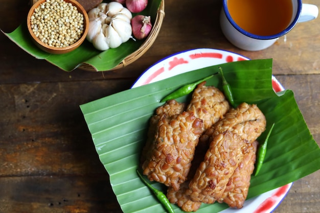 Tempe bacem is traditional food from Java Indonesia served on the wooden plate with banana leaf