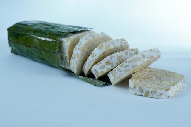 Foto tempe di semi di soia fermentati in foglie di banano