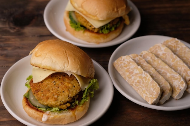 Tempeh burger. veggie vegan burger, low carb. diet food. burger\
tempe. on a white plate wooden table