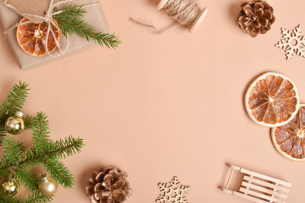 템플릿은 크리스마스를 위한 다양한 자연 장식이 있는 베이지색 배경의 프레임입니다.