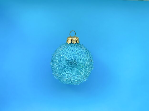 A template for your projects on a festive theme in the form of a blue Christmas ball on a background of the same color.  Happy New Year and Christmas concept.