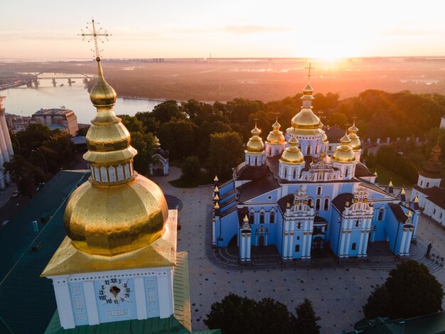 Temple by building against sky during sunset