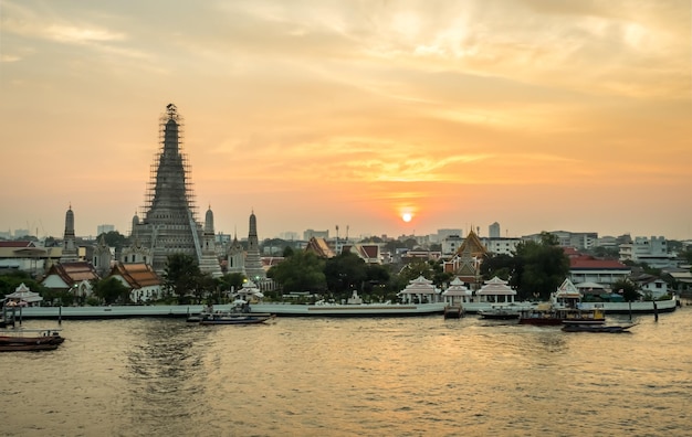 タイのバンコクの夕暮れの夕方の空の下、チャオプラヤー川の夜明けの寺院のメインパゴダ側