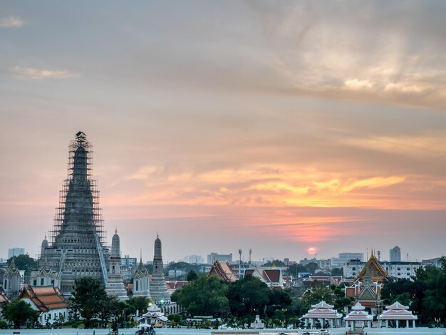 タイのバンコクの夕暮れの夕方の空の下、チャオプラヤー川の夜明けの寺院のメインパゴダ側