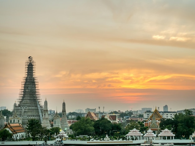 Temple of Dawn main pagoda side of Chaophraya river under twilight evening sky in Bangkok Thailand