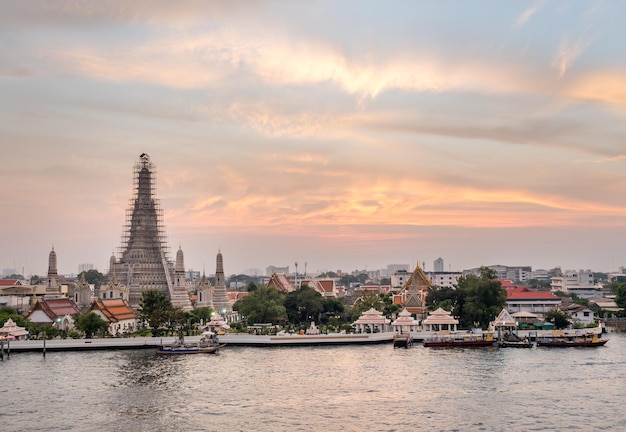 タイのバンコクの夕暮れの夕方の空の下、チャオプラヤー川の夜明けの寺院のメインパゴダ側