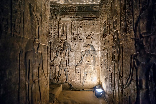 에드푸 신전은 에드푸의 나일강 서쪽 제방에 위치한 이집트 사원입니다. 벽에 이미지가 있는 사원의 얽힌 복도
