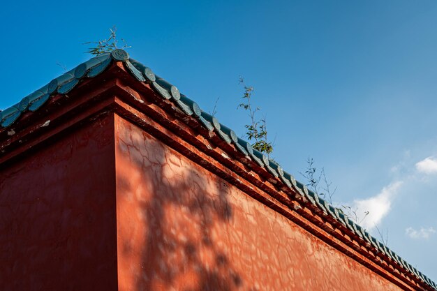 晴天の寺院では、太陽が赤い壁に影を落としました