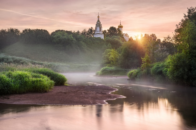 Temple on the high bank of the Istra River on an early foggy morning