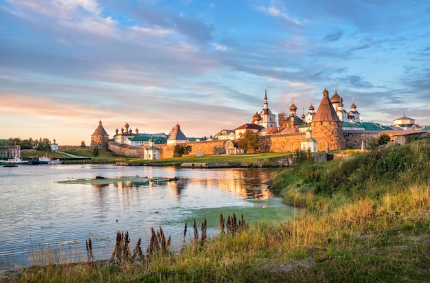 Temples and towers of the Solovetsky Monastery on the Solovetsky Islands and the grassy shore