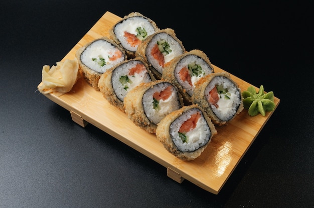 Tempura roll met zalm en avocado op houten plank