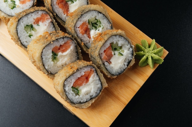 Tempura roll met zalm en avocado op houten plank