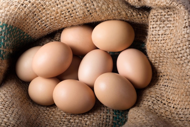 Ten brown eggs on burlap Top view Poultry farm protein