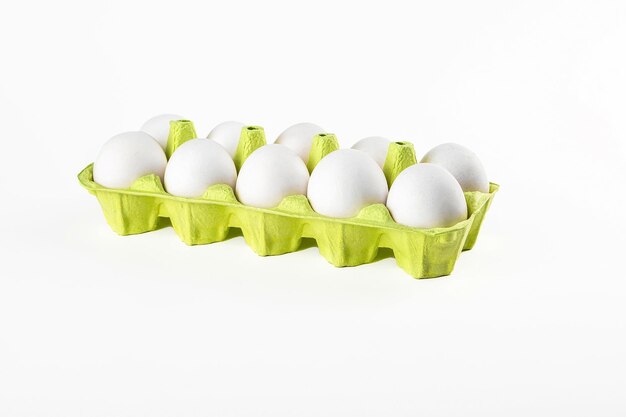 Ten chicken eggs in cardboard cassette isolated on white