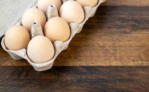 Ten chicken eggs in a cardboard tray on the table