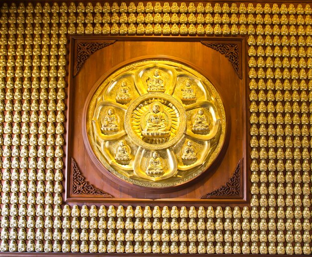 Photo ten thousand golden buddhas lined up along the wall of chinese temple