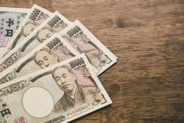 Ten thousand Japanese Yen banknotes on wood table