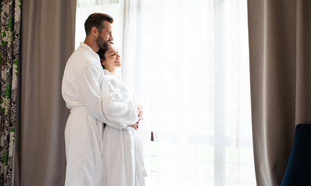 Tender and a beautiful young couple in love in white bathrobes