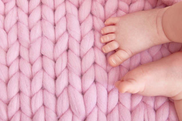 Tender child's legs on a knitted blanket