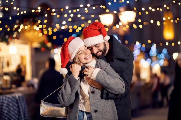 Tender Christmas couple hugging outdoors on New Year's eve