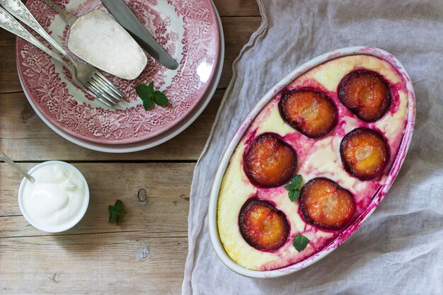 Tender curd casserole with plums and semolina, served with cinnamon and mint leaves