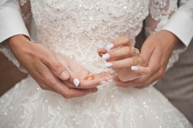 The tender embrace of the hands of a husband and wife with wedding rin