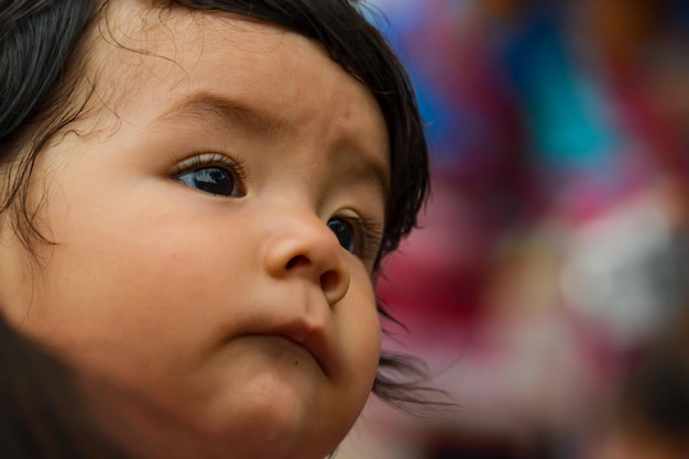 Tender face of a baby in the arms of his mother